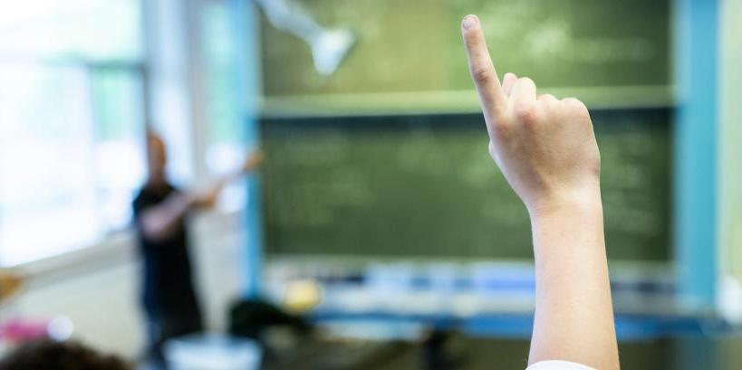 Elev med en finger i vejret i klasselokale